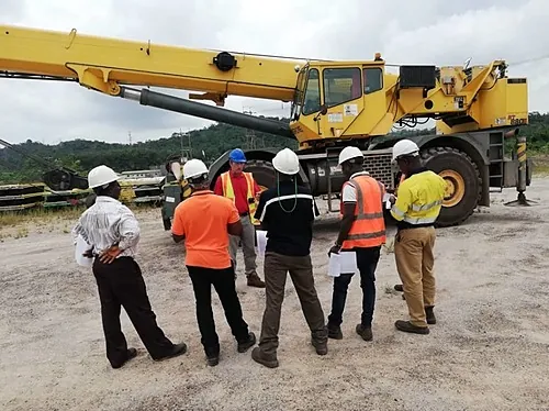 Grue mobile tout-terrain et groupe de stagiaires casqués, formation R483