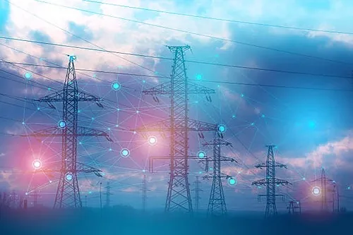Pylônes électriques haute tension reliés par un réseau de points lumineux, visuel d'illustration de l'énergie électrique